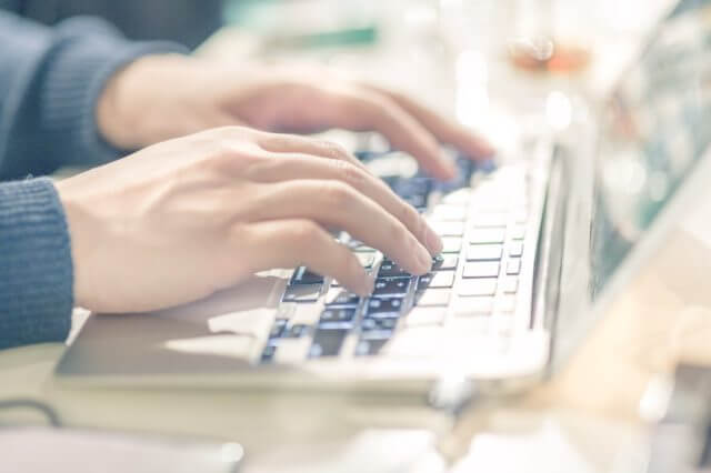 ノートPCをタイピングする男性